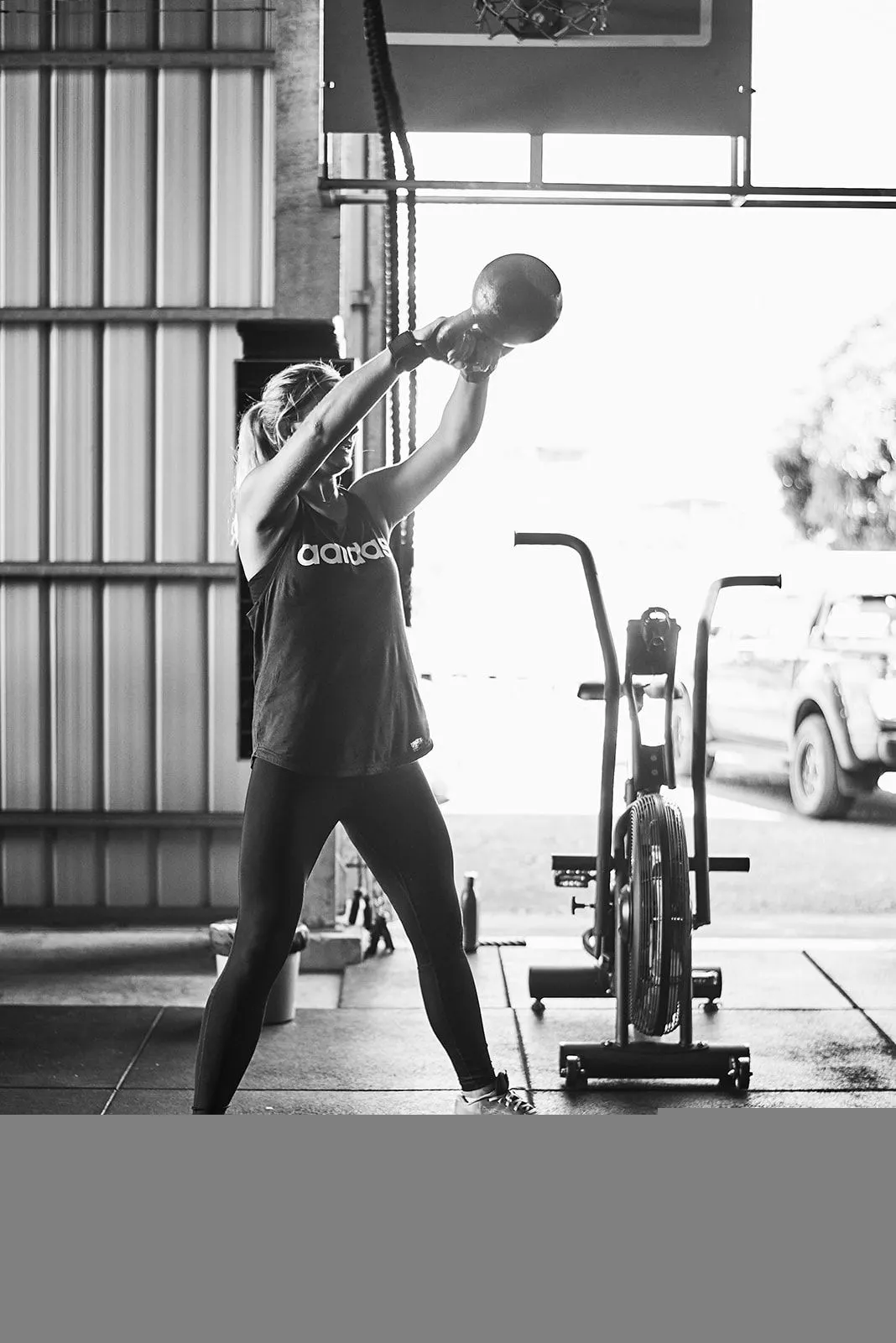Un swing de kettlebell devant la porte ouverte, en contre-jour.