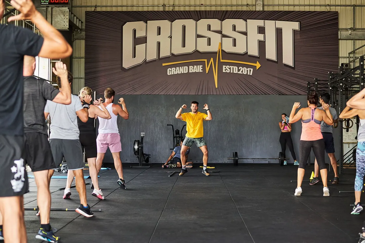 La fresque CROSSFIT GRAND BAIE ESTD. 2017 sur le mur du fond, avec un cours qui s'échauffe devant.