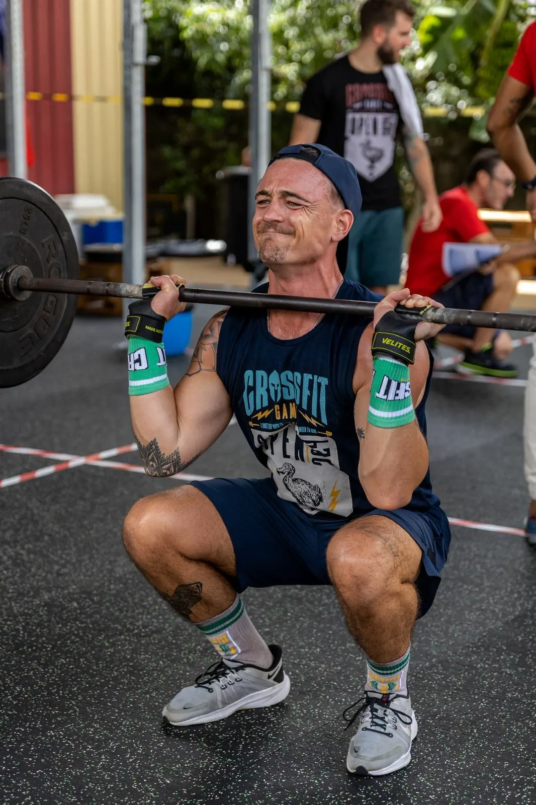 Un front squat vu de près, la barre en position, le regard fixe.